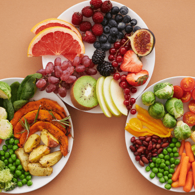 Three plates of healthy foods filled with fruits and vegetables, representing dental health