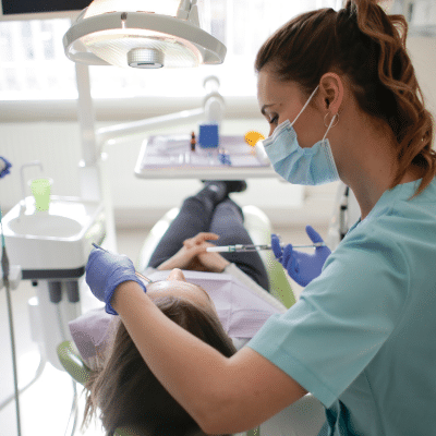 Female dentist working on a patient's teeth, representing reconstructive dentistry