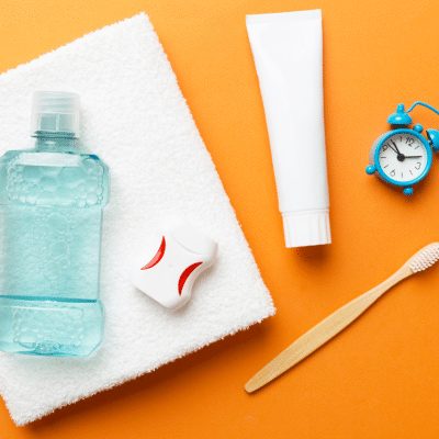 Toothbrush, floss, mouthwash, timer, towel, representing daily oral hygiene routine