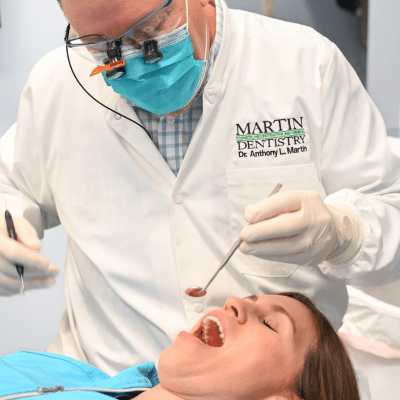 Dr. Anthony martin examining a patient, representing the difference between acid erosion and cavities